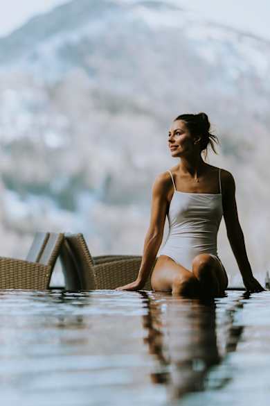 Eine Frau sitzt am Rand eines Pools