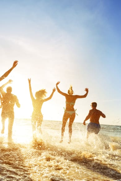 Partyfreunde im Sonnenuntergang am Strand