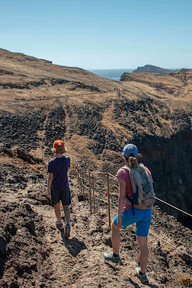Eine Frau und ein Junge wandern an der Küste von Madeira.