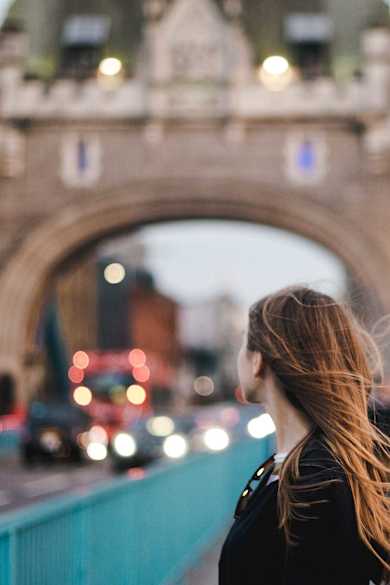 Eine junge Frau steht auf der Tower Bridge in London.
