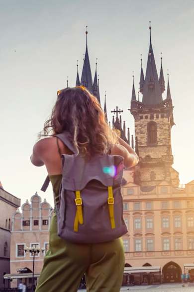 Eine junge Frau macht ein Foto der Tyn Kirche in Prag.