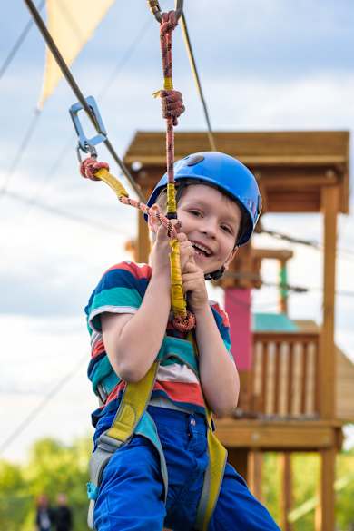Ein kleiner junge in einem Kletterpark