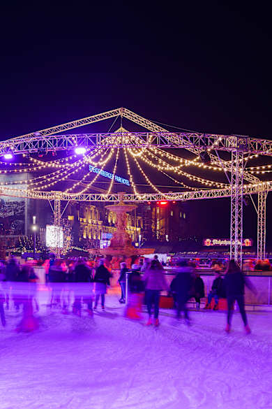 Eine Eislauffläche am Abend mit pinker Beleuchtung
