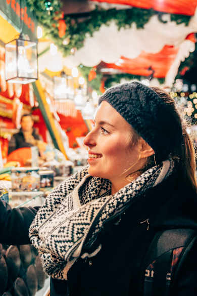 Eine Frau lächelt ein Lebkuchenherz an.