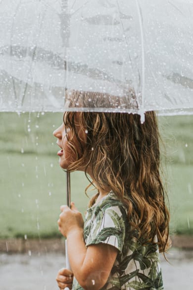 Mädchen hält ein Regenschirm.