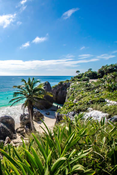 Menschen baden an einem Strand in Mexiko. © AlagnaMarco/Moment via Getty Images