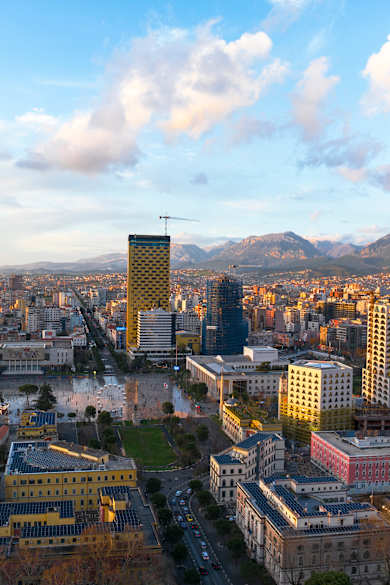Blick über die Skyline von Tirana mit Bergen im Hintergrund.
