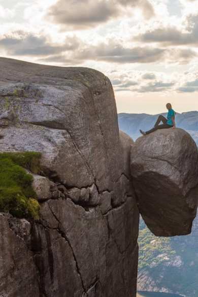 Eine Touristin auf dem norwegischen Kjeragbolten. © iStock via Getty/kotangens