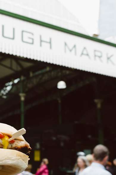 Ein Mann hält ein Sandwich vor dem Borough Market in London.