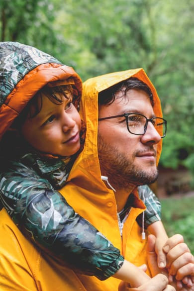 Vater und Sohn wandern an einem regnerischem Tag. © StockRocket/iStock / Getty Images Plus via Getty Images