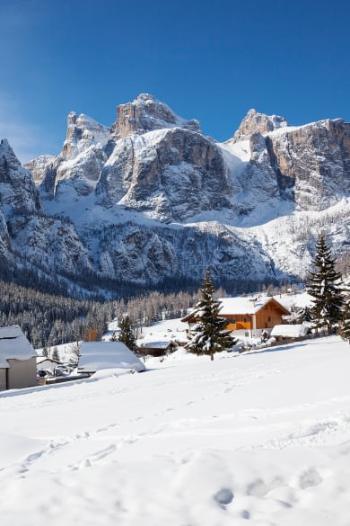 verschneite Häuser mit Bergen im Hintergrund in der Provinz Bozen in Südtirol © Johanna Huber/HUBER IMAGES