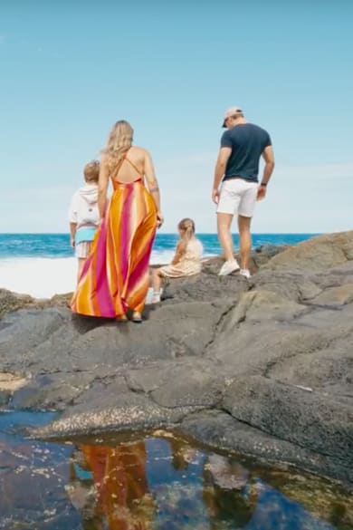 Mutter, Vater und zwei Kinder an einem steinigen Strand auf Fuerteventura, Kanaren.
