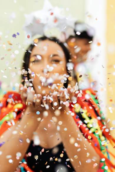 Frau feiert Karneval mit Freunden und Konfetti.