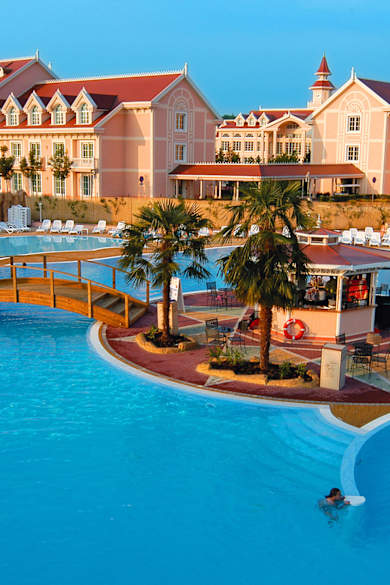 Blauer Pool mit Hotelanlage dahinter