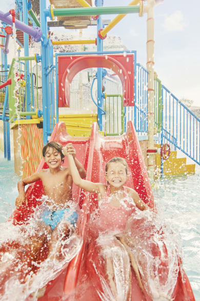 Kinder auf einer kleinen Rutsche im Caribe Aquatic Park in der Port Aventura World