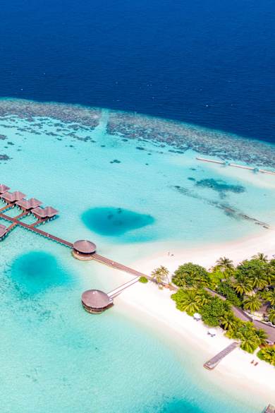 Luftbild eines Atolls mit Wasserbungalows