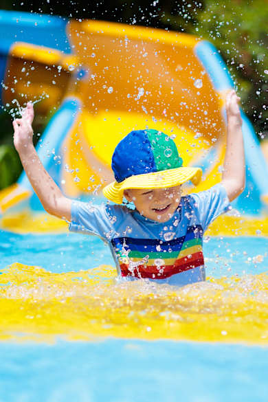 Kleinkind beim Rutschen im Wasserpark  © Getty Images - FamVeld