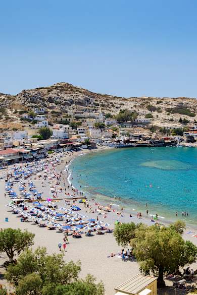 Ein Strand mit blau-weißen Sonnenschirmen