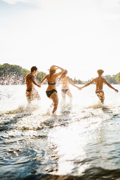Freunde laufen in einen Badesee