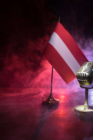 Mikrofon auf dem Hintergrund einer unscharfen Flagge Österreichs © zef art