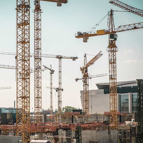 Zahlreiche Baukräne in einer Stadt.