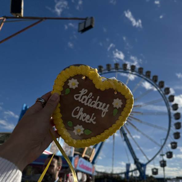 Lebkuchen Herz mit HolidayCheck Aufschrift im Hintergrund  das Riesenrad, Oktoberfest, München