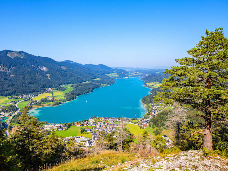 Blick aus der Luft auf einen länglichen See und Berge