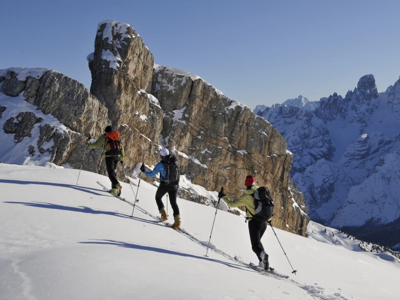 Gruppe von Personen läuft Ski in den Dolomiten © iStock.com/Gorfer