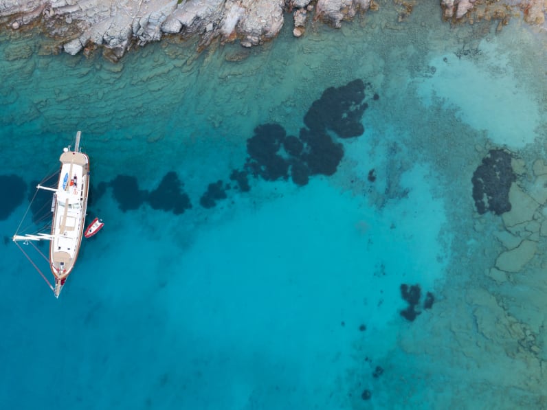 Luftaufnahme von einem Segelschiff in türkisfarbenem Meer © iStock.com/bodrumsurf