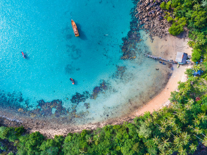 Luftaufnahme von einem Strand auf Malta mit türkisem Wasser und Booten © iStock.com/themorningglory