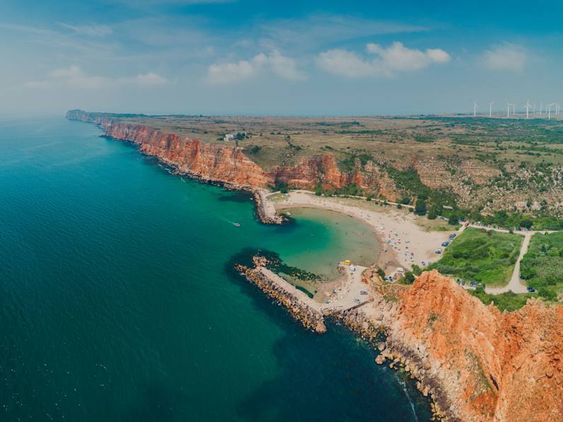 Luftaufnahme des Bolata-Strands mit geschwungener Bucht, Sandstrand und roten Klippen am Kap Kaliakra in Bulgarien