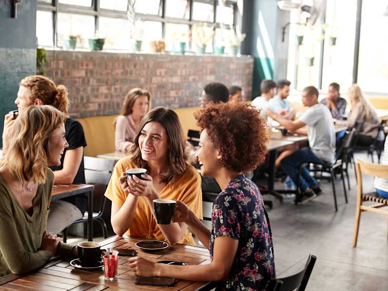 Viele Menschen sitzen in einem Café.