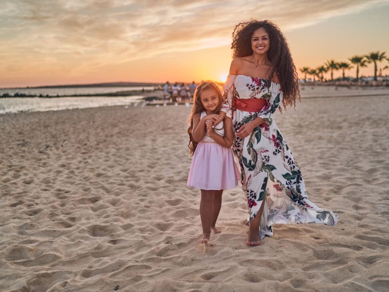 Mutter und Tochter gemeinsam am Strand bei Sonnenuntergang © iStock.com/Anton Dimov