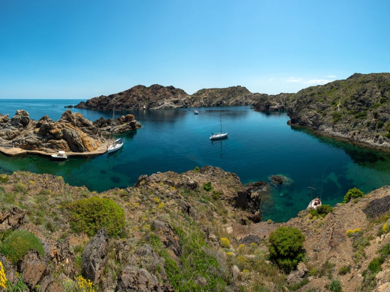 Fünf kleine Boote sind in einer Bucht vor Anker gegangen