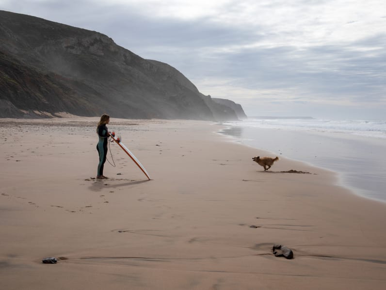 Surferin mit Hund, Portugal © AscentXmedia/iStock / Getty Images Plus via Getty Images