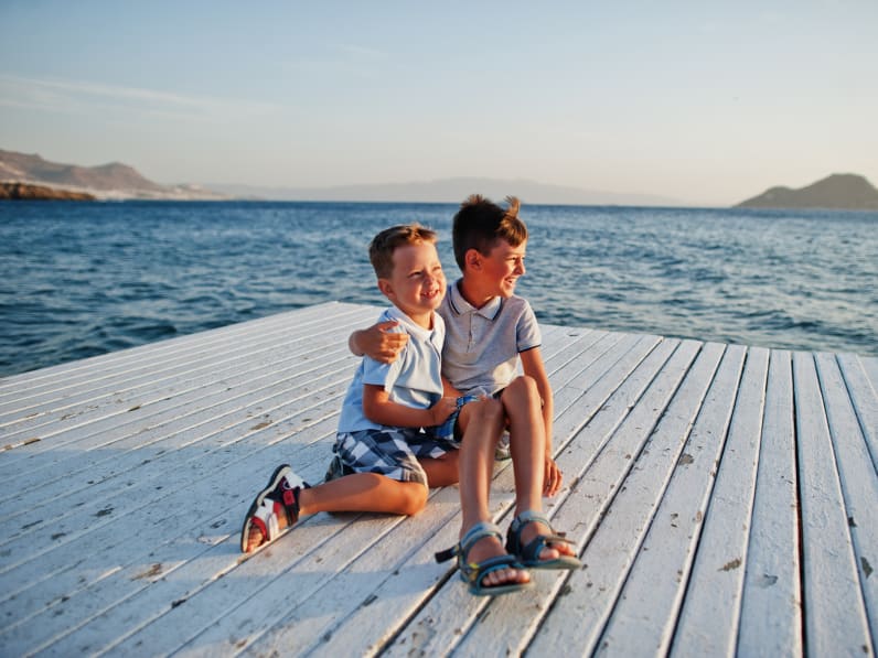 Zwei Brüder sitzen im Türkei Resort am Pier am Mittelmeer ©iStock.com/ASphotowed