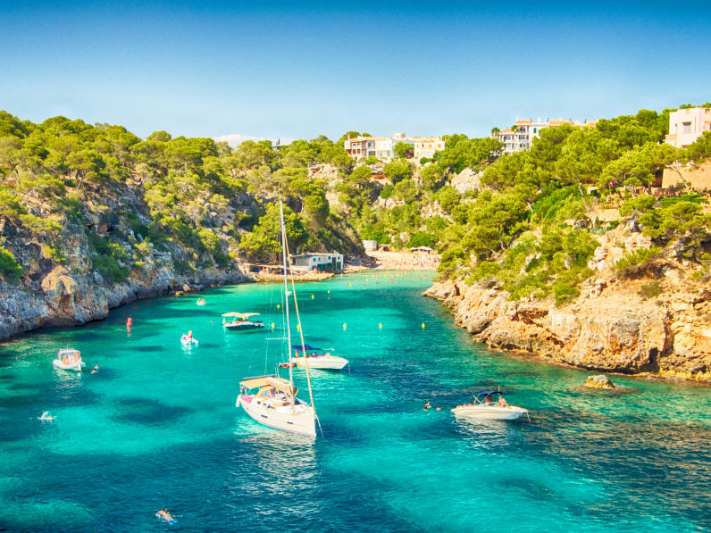 blaues Meer in einer Bucht von Mallorca mit einigen Booten © iStock.com/Josep Bernat Sànchez Moner