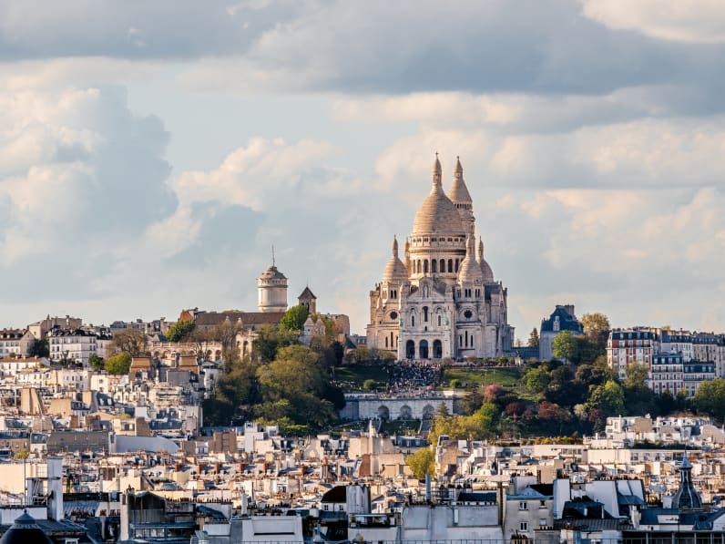 Blick über Häuserdächer in Paris auf Sacré-Cœur.