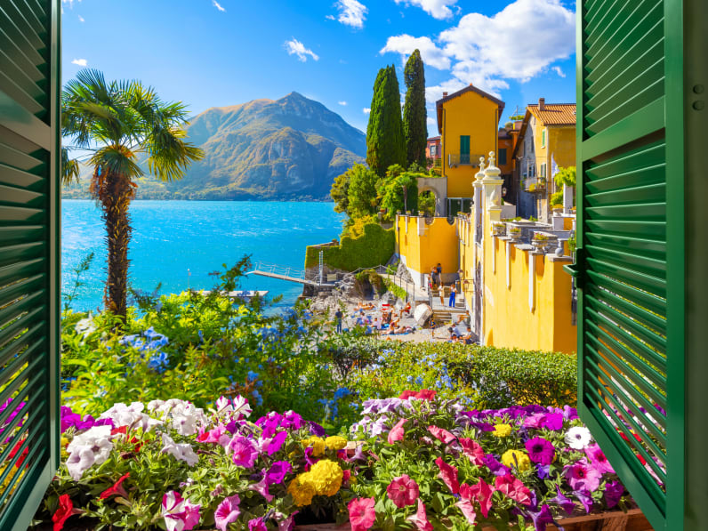 Blick von einem Fenster auf schöne Vegetation und Varenna, Comer See, Italien.