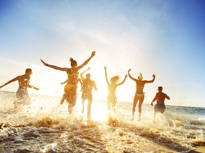 Partyfreunde im Sonnenuntergang am Strand