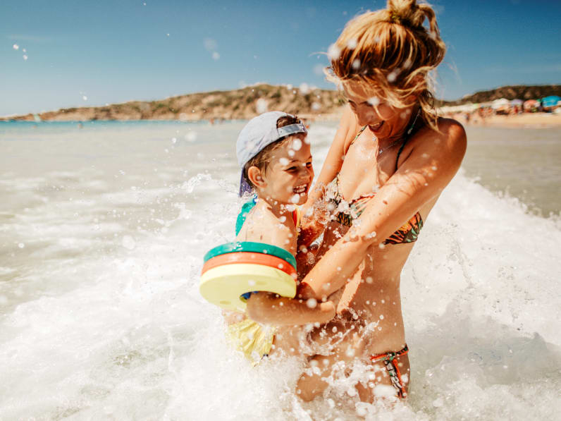 junge Mutter mit ihrem Sohn, die das Baden im Meerwasser genießen © iStock.com/AleksandarNakic