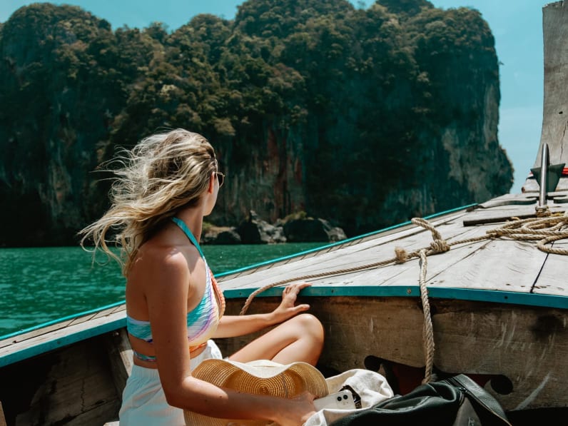 Eine junge Frau sitzt im thailändischen Boot auf dem Weg nach Krabi, Thailand.