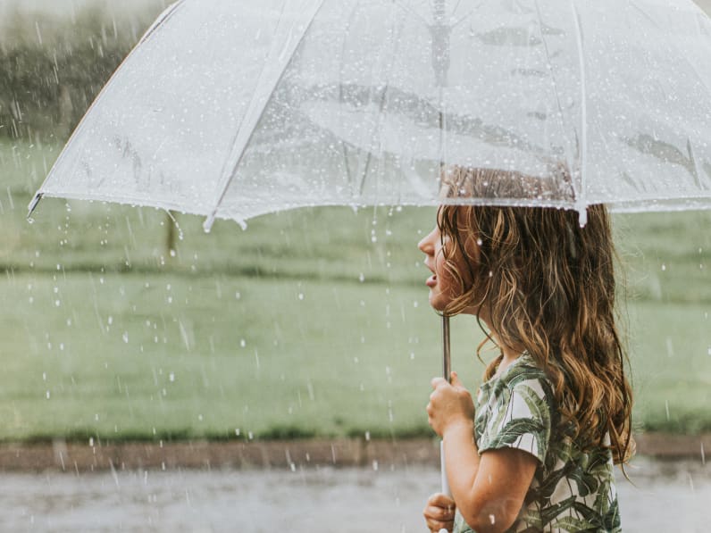 Mädchen hält ein Regenschirm.