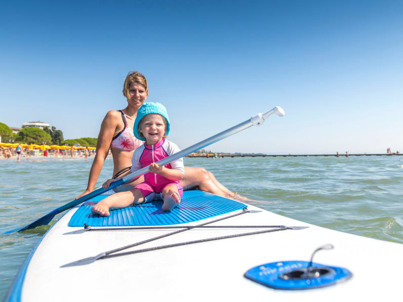 Mutter und Tochter auf einem Surfbrett © mmphoto – stock.adobe.com