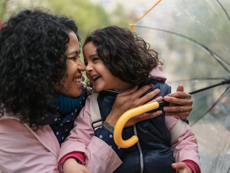 Mutter und Tochter gemeinsam mit einem Regenschirm.