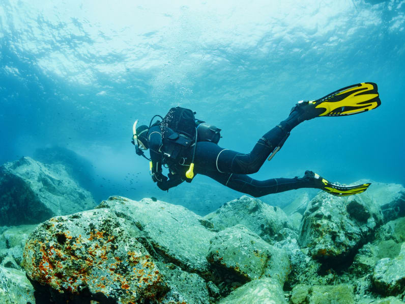männlicher Taucher genießt blaues flaches Wasser © iStock.com/ultramarinfoto