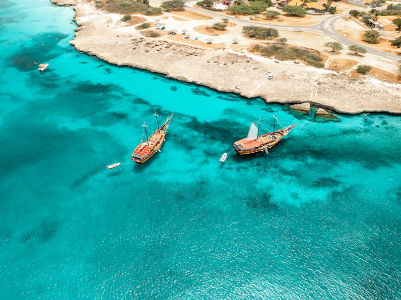 Zwei Schiffe vor einer Küste.