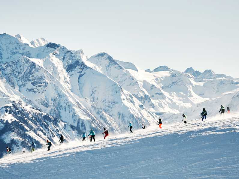 Eine Gruppe SkifahrerInnen auf einer Piste in Zell am See, Österreich.