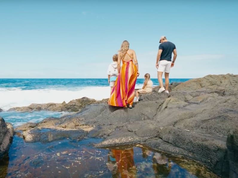 Mutter, Vater und zwei Kinder an einem steinigen Strand auf Fuerteventura, Kanaren.