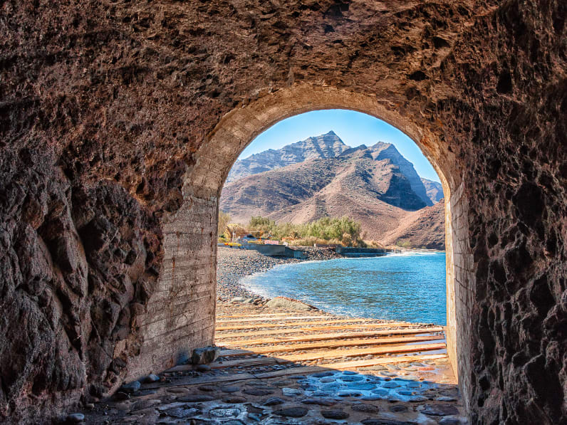 Blick durch einen kurzen Tunnel auf den Aldea Strand auf Gran Canaria